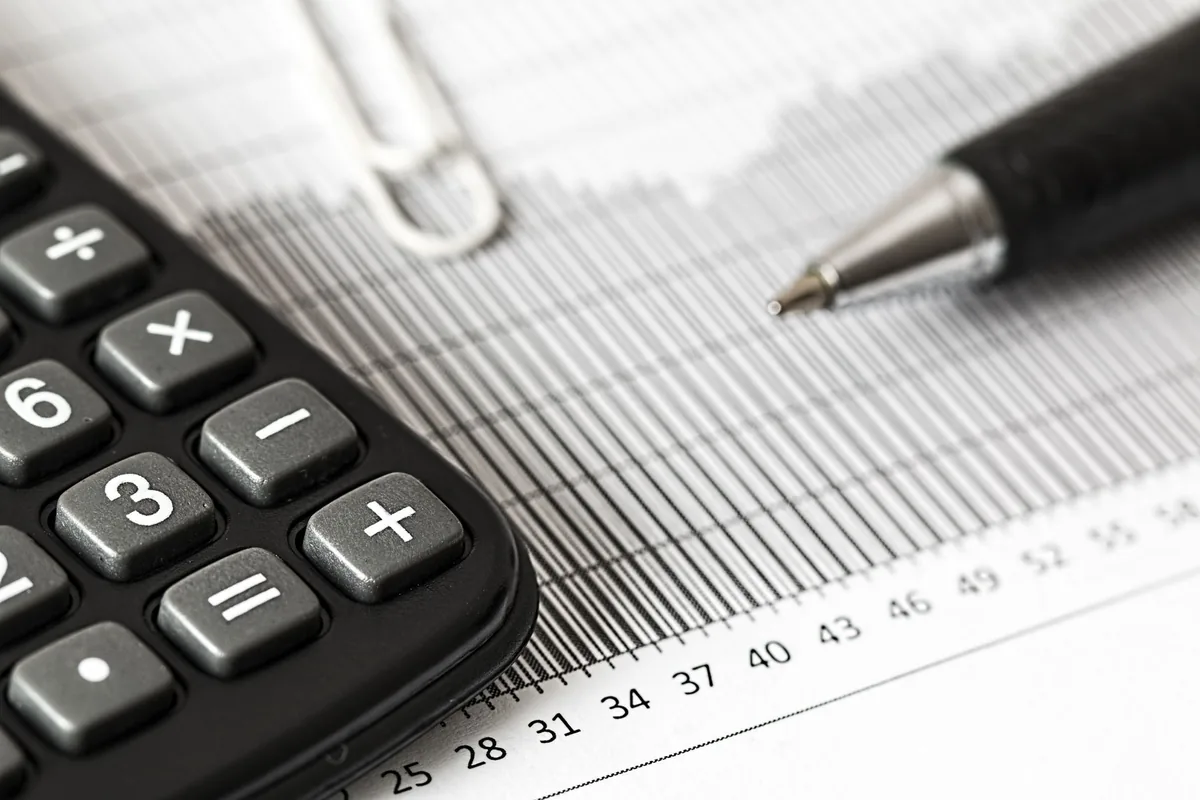 Calculatrice et documents de paie posés sur un bureau de bureau