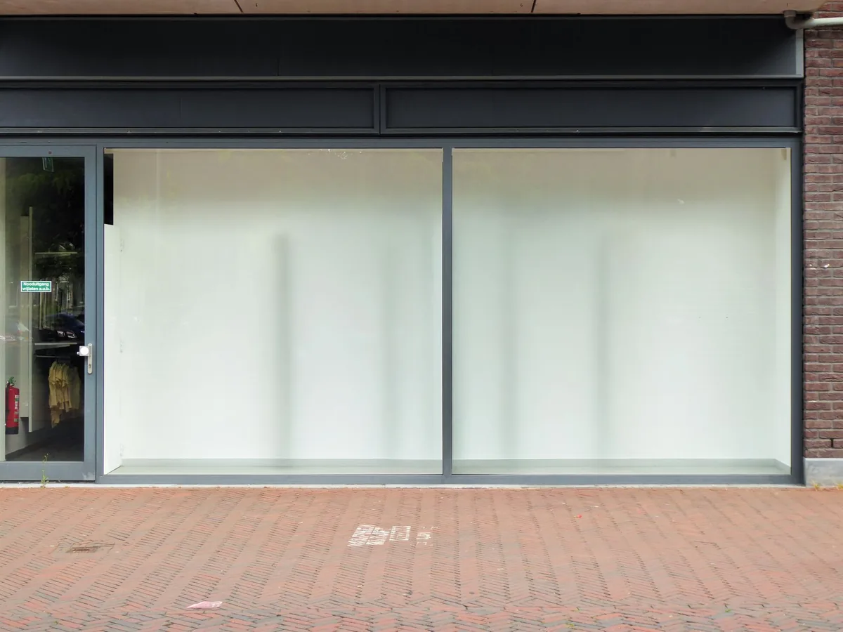 Devanture de commerce vide avec vitrine en attente d'un nouveau locataire