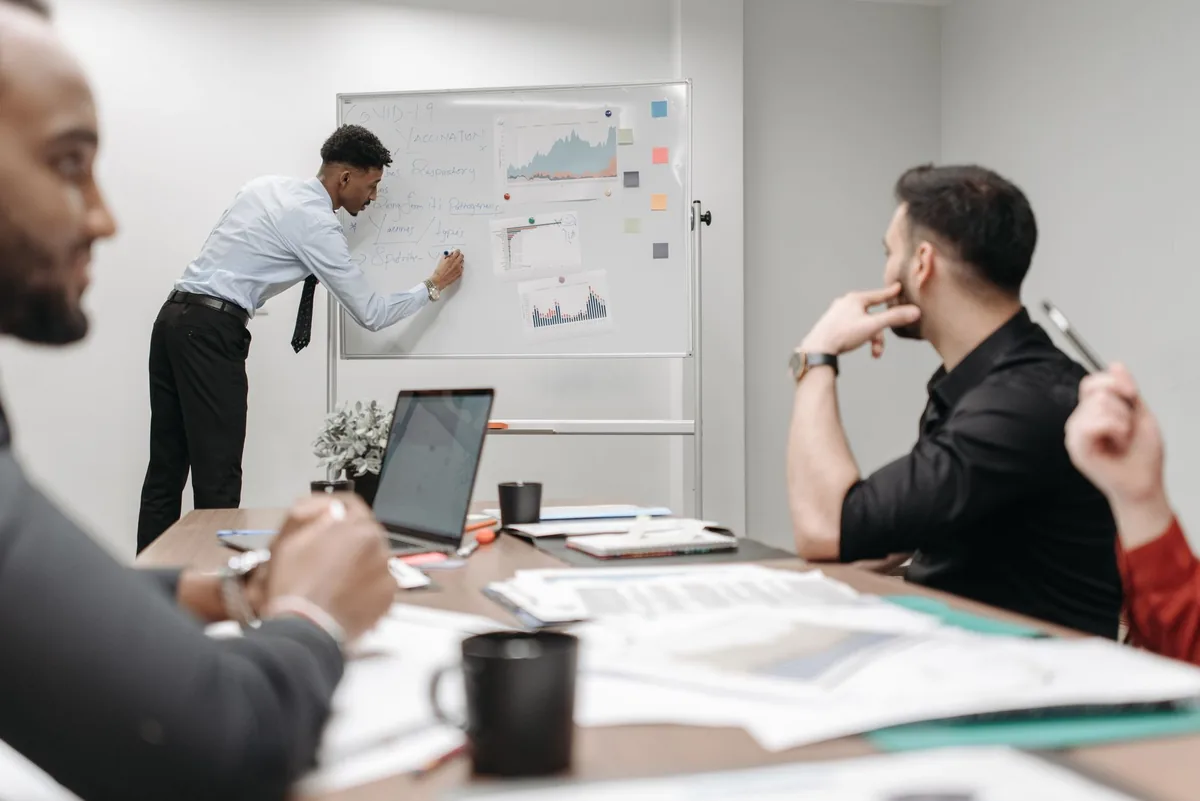Équipe de direction autour d'un tableau blanc lors d'un atelier d'analyse stratégique