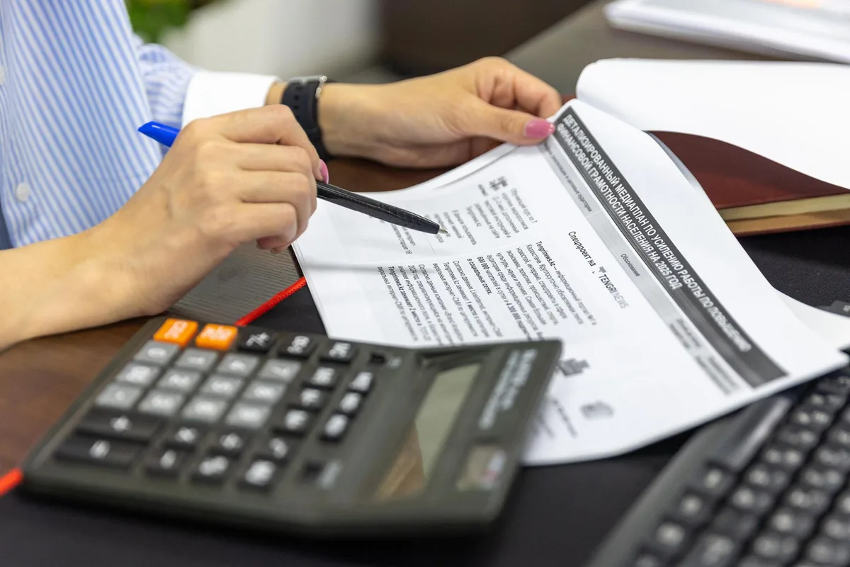 Documents financiers et bilan comptable posés sur un bureau avec une calculatrice
