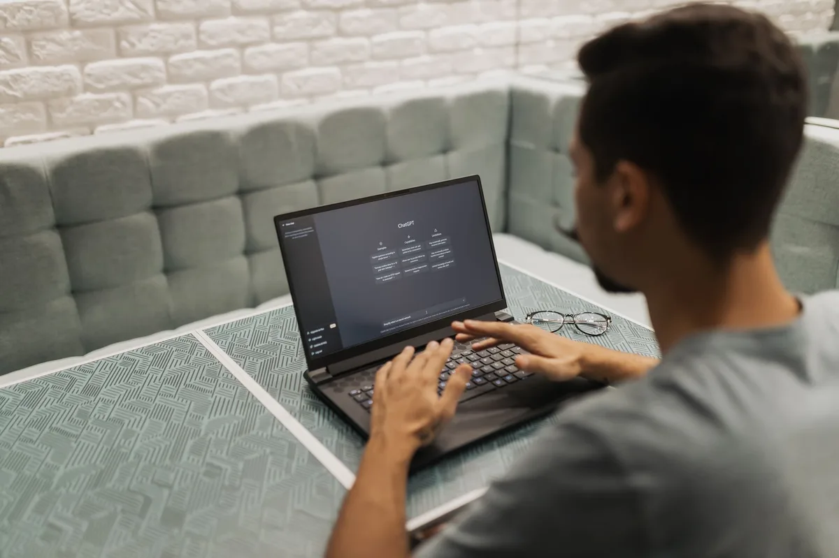 Dirigeant de PME utilisant un assistant d'intelligence artificielle sur son ordinateur portable