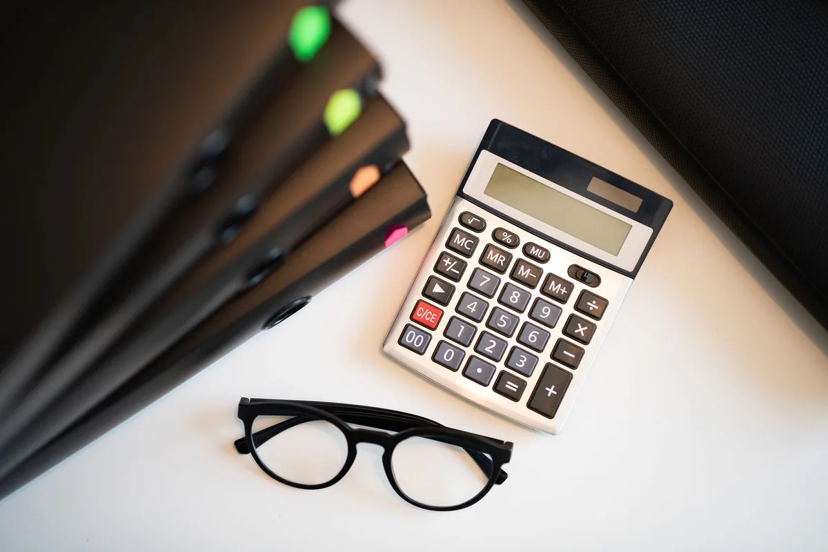 Documents financiers, calculatrice et stylo sur un bureau, représentant une opération de réduction de capital