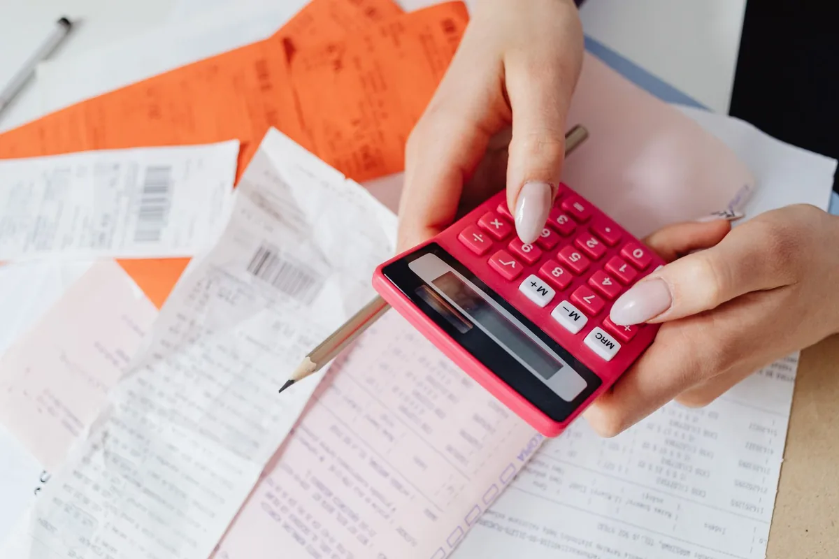Facture et calculatrice posées sur un bureau, illustration du calcul de la TVA